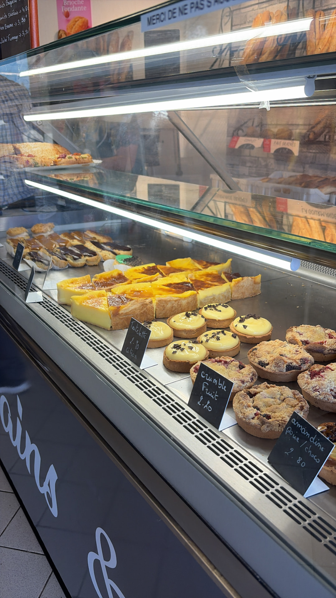 Vitrine de pâtisseries : flans, tartelettes citron, crumbles aux fruits